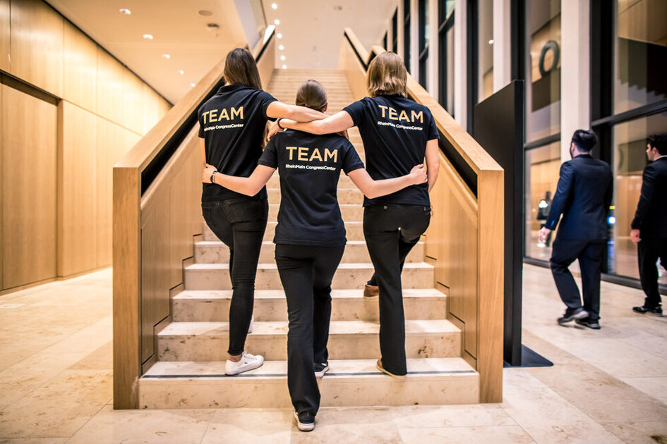 Drei Frauen in Team-T-Shirts auf der Treppe