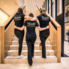 Drei Frauen in Team-T-Shirts auf der Treppe