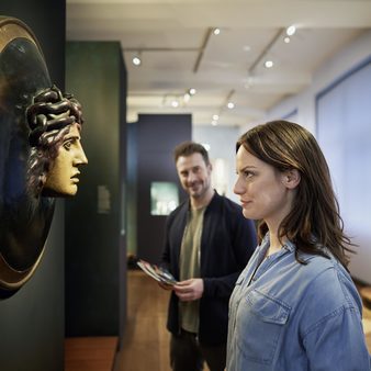 Eine Frau guckt eine Skulptur im Museum an