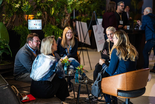 Gruppe sitzend am Tisch in einer Lounge